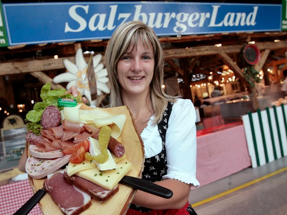 Servierfrau mit Käse- und Wurstwaren auf Tablett