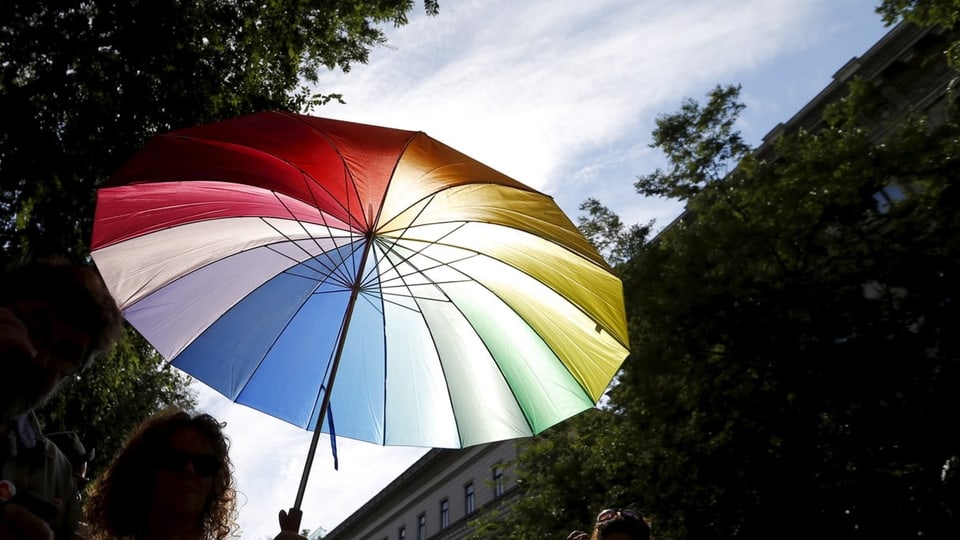 Frau mit Schirm in Regenbogenfarben an Gay Pride in Budapest