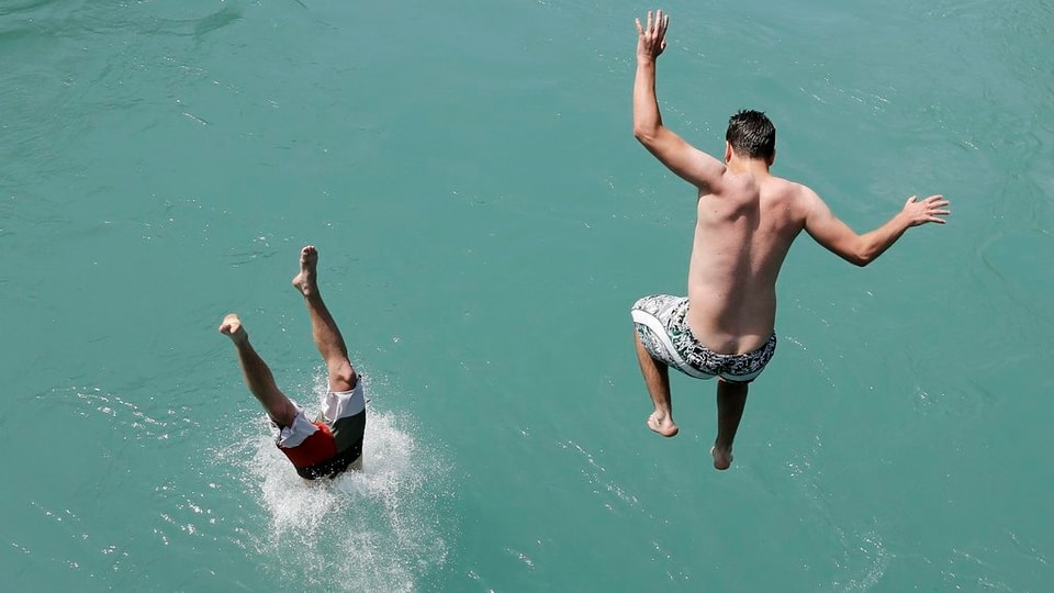 Zwei junge Männer springen in die Aare bei Bern