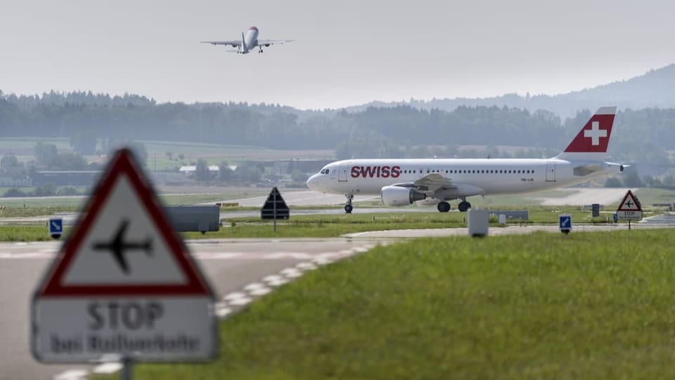 Ein Verkehrsflugzeug der Swiss Rollt auf das Rollfeld des Flughafen Zueich und ueberquert die Startbahn.