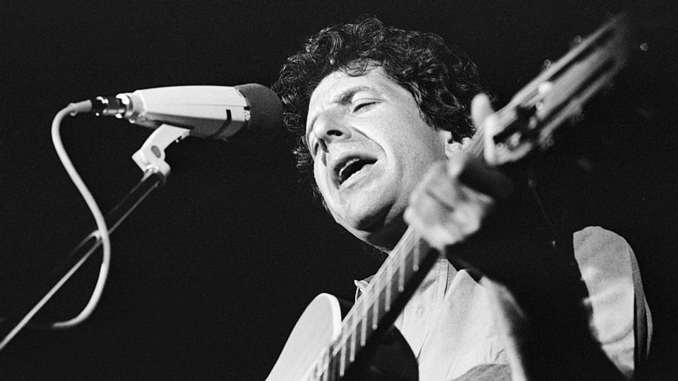 Der kanadische Musiker Leonard Cohen singt mit Gitarre in der Hand und geschlossenen Augen auf der Bühne des Jazz-Festivals in Montreux.