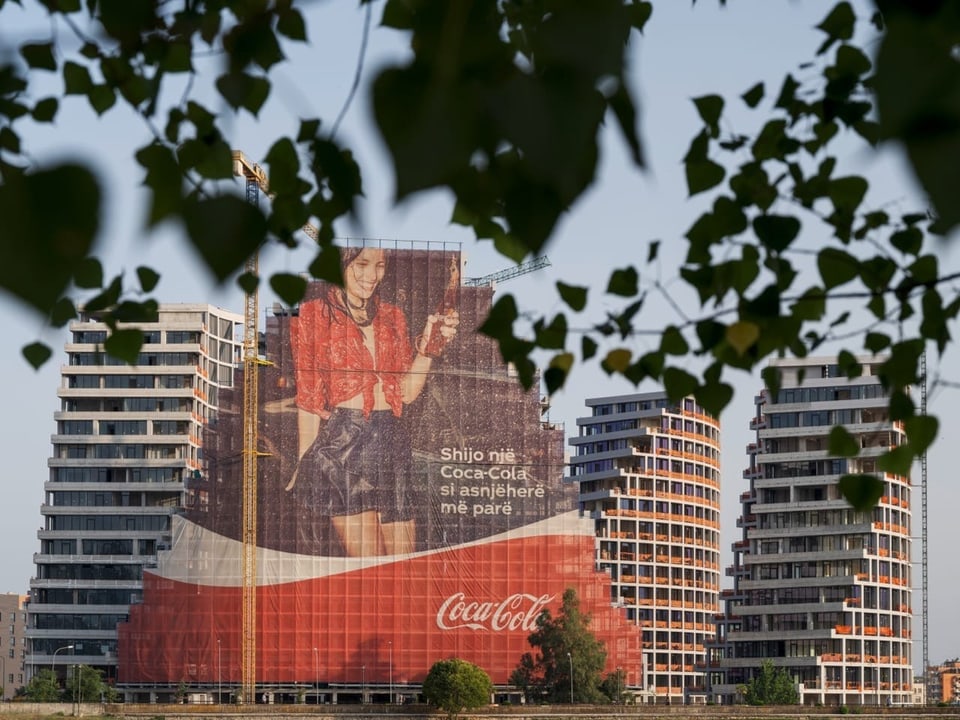 Hochhausfassaden mit einer grossen Coca Cola-Werbung.