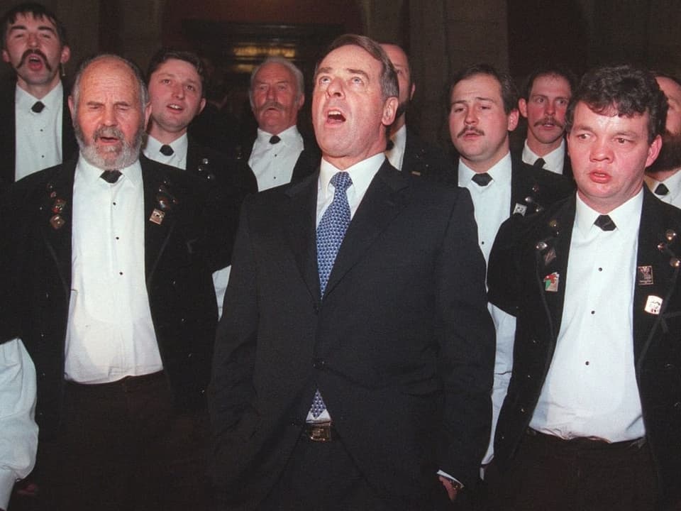 Nach seiner Wahl zum Bundespräsidenten am 15. Dezember 1999 jodelt Adolf Ogi mit einer Berner Oberländer Jodelgruppe.