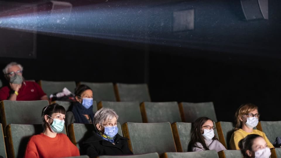 Menschen mit Maske im Kino