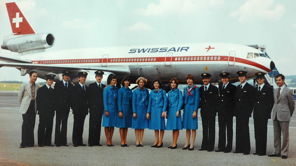 Eine Gruppe uniformierter Männer und Frauen vor einem Flugzeug.