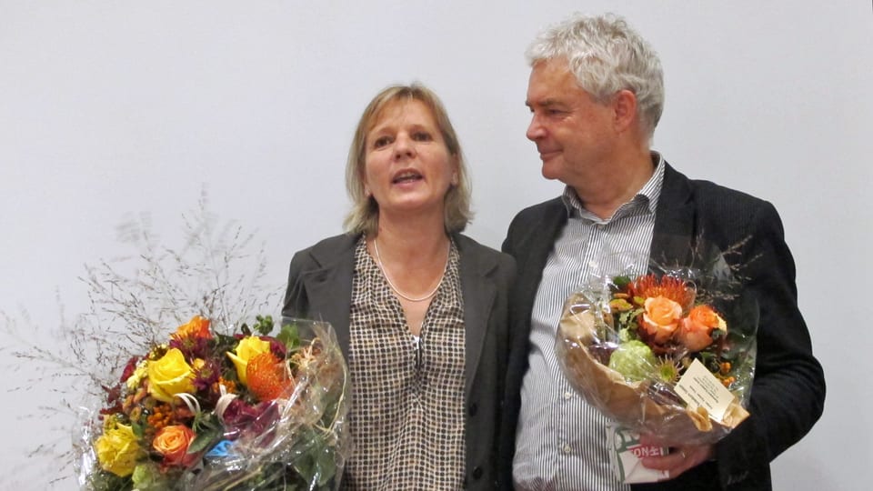 Frau und Mann mit Blumen in der Hand.