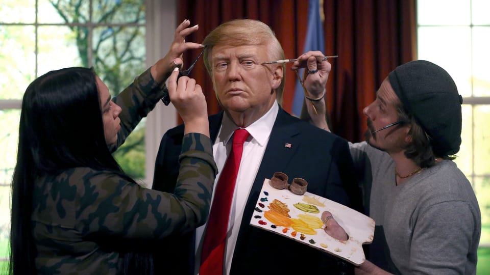 Zwie Künstler bemalen eine Trump-Wachsstatue bei Madame Tussauds.