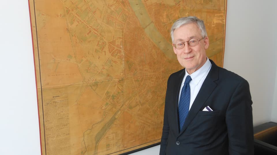 Bernhard Christ in seinem Büro vor einem historischen Basler Stadtplan