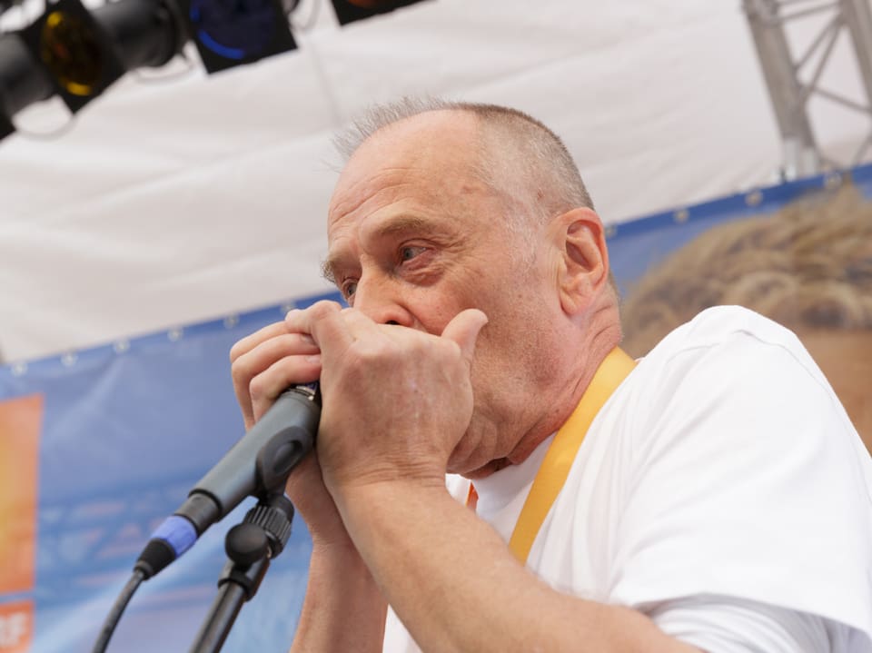 Joschi Kühne spielt Mundharmonika.