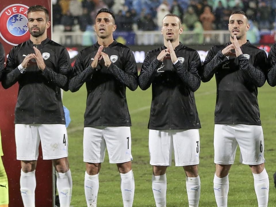 Israels Spieler formen während der Nationalhymne mit den Händen ein gebrochenes Herz.