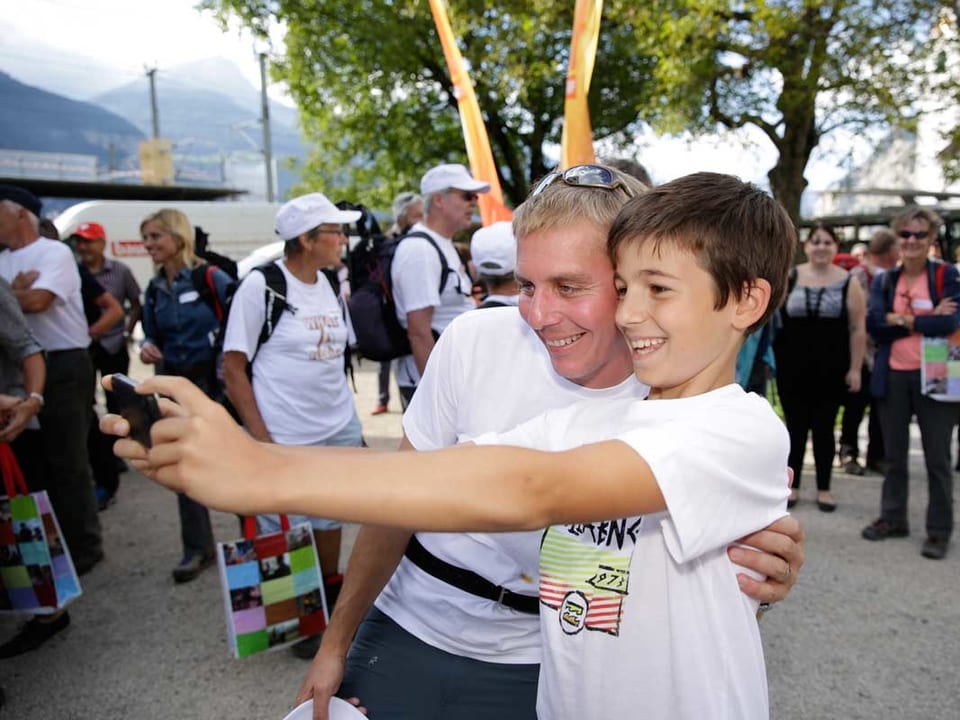 Reto Scherrer macht mit einem kleinen Jungen ein Selfie.