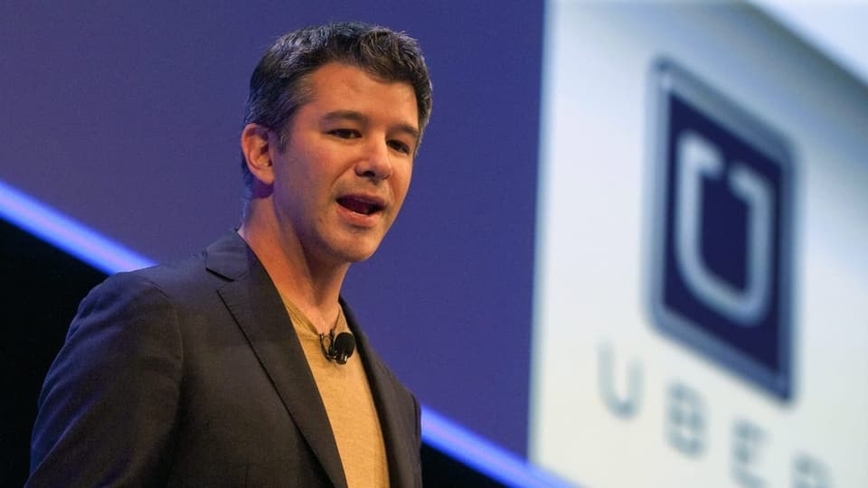 Travis Kalanick spricht auf einer Bühne. Hinter ihm ist ein Uber-Logo zu sehen.