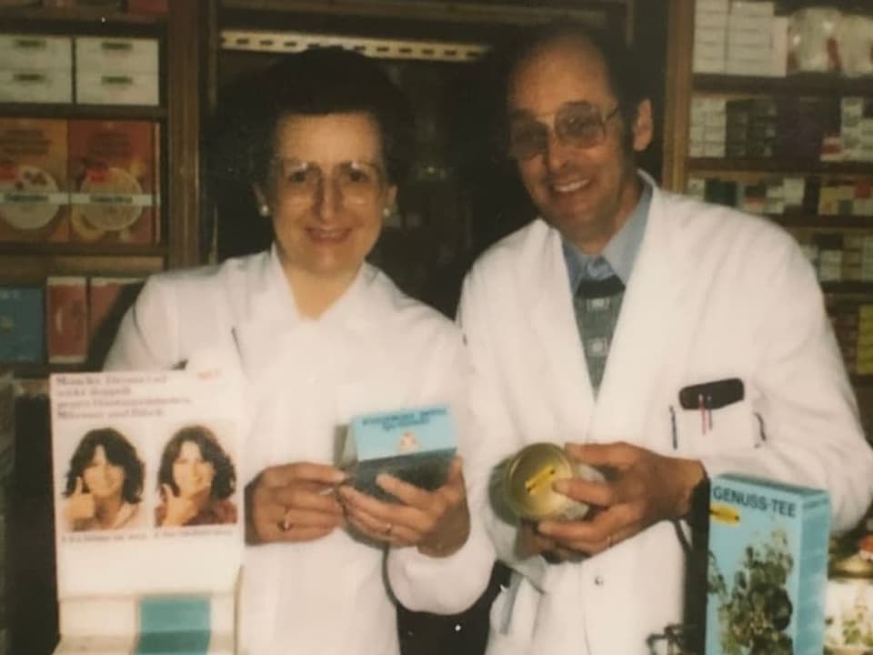 Das Apotheker-Ehepaar hält verschiedene Heilmittel in der Hand. 