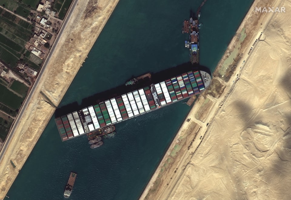 Ein Containerschiff liegt quer im Suezkanal. 