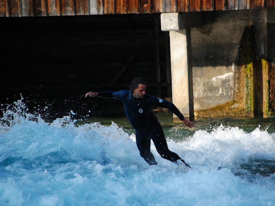 Fluss-Surfer reitet die Welle bei der Thuner Mühleschleuse