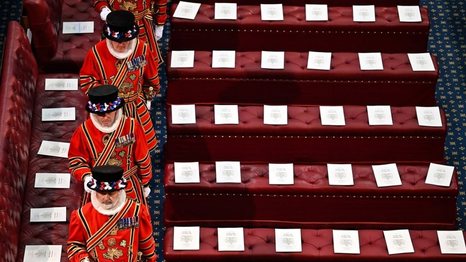 Vier Männer in roten Kostümen, die das House of Lords vorbereiten