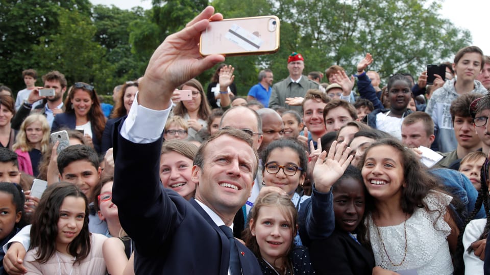 Macron macht ein Selfie mit jugendlichen Fans.