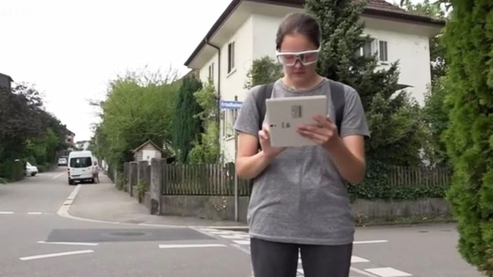 Eine Frau mit einem Tablet auf der Strasse.