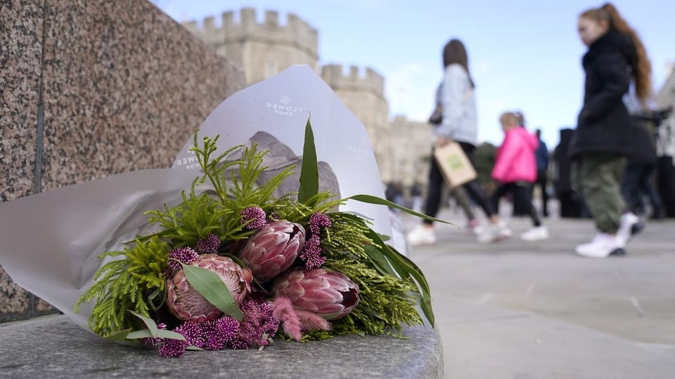 Menschen hinterlassen vor dem Schloss Windsor Blumen für Prinzessin Kate.