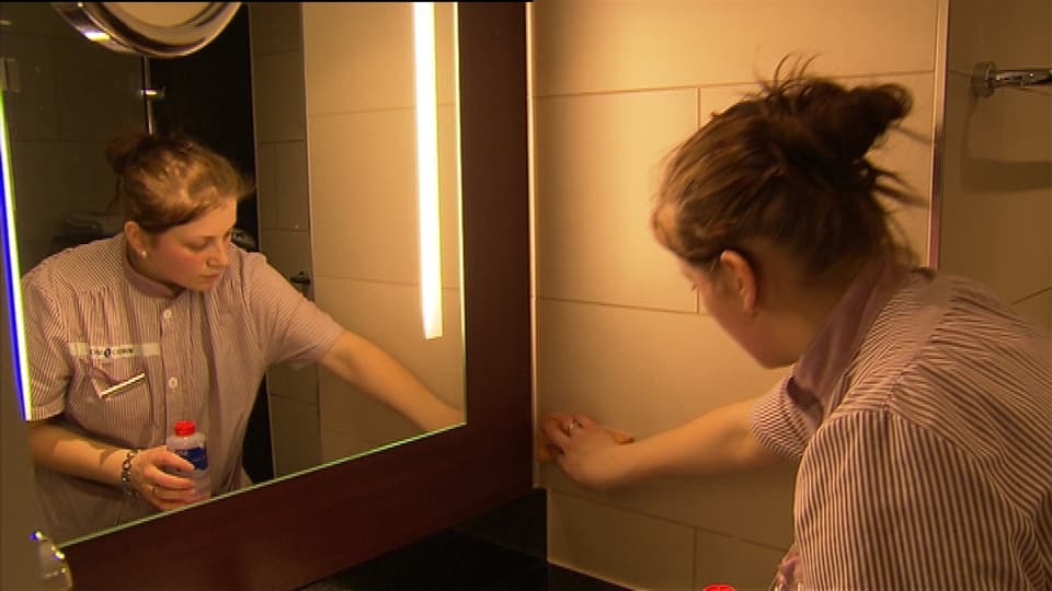 Putzfrau putzt Spiegel