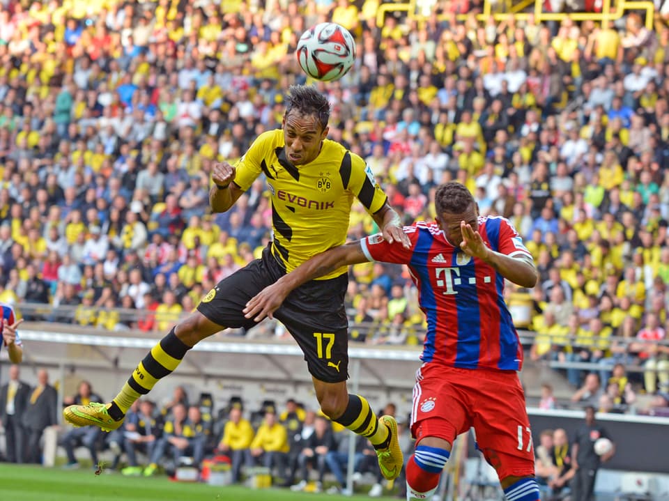 Dortmunds Pierre-Emerick Aubameyang steigt gegen Bayerns Jerome Boateng in die Luft und kommt mit dem Kopf vor seinem Gegner an den Ball.