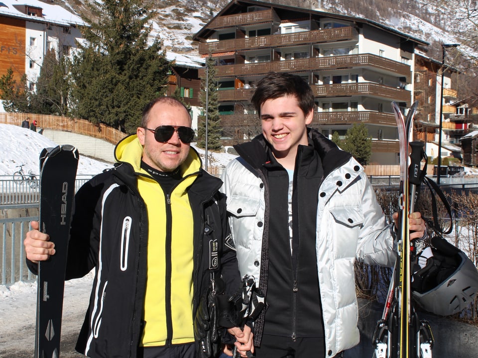Zwei Moskauer, Vater und Sohn, in Skibekleidung mit Skis.