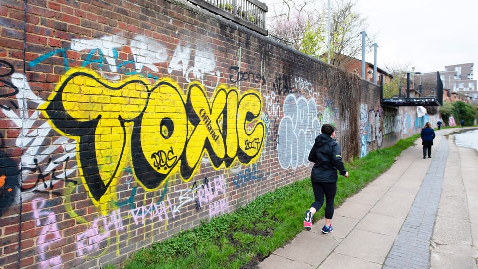 An einer Backsteinmauer ist in gelben grossen Buchstaben das Wort «toxic» gesprayt.