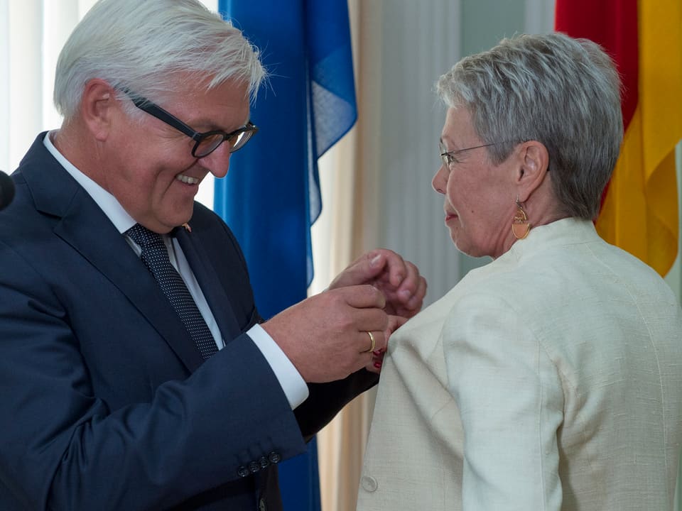 Deutschlands Aussenminister Steinmeier steckt Heidi Tagliavini das Bundesverdienstkreuz an.