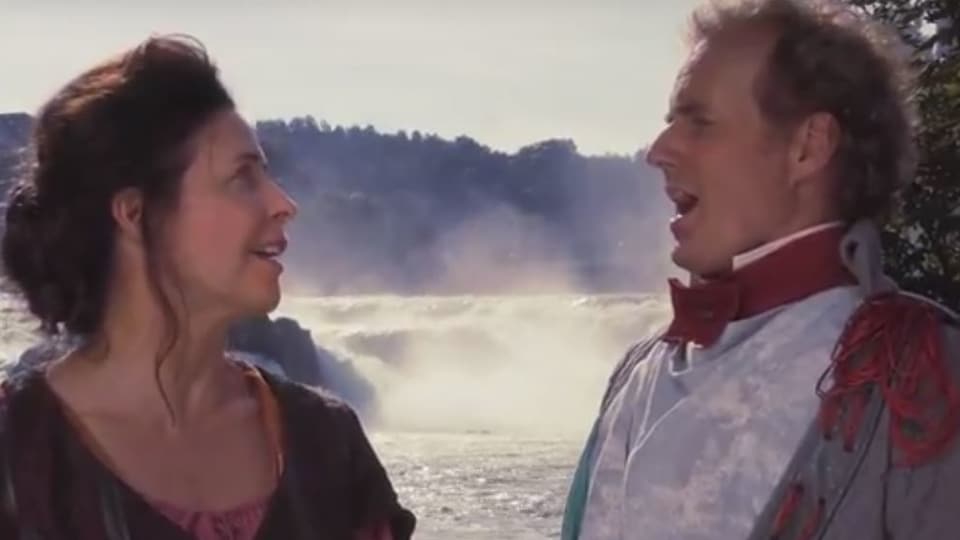 Hauptdarstellerin Masha Karell und Paul Erkamp als Gerichtsschreiber stehen singend vor dem Rheinfall