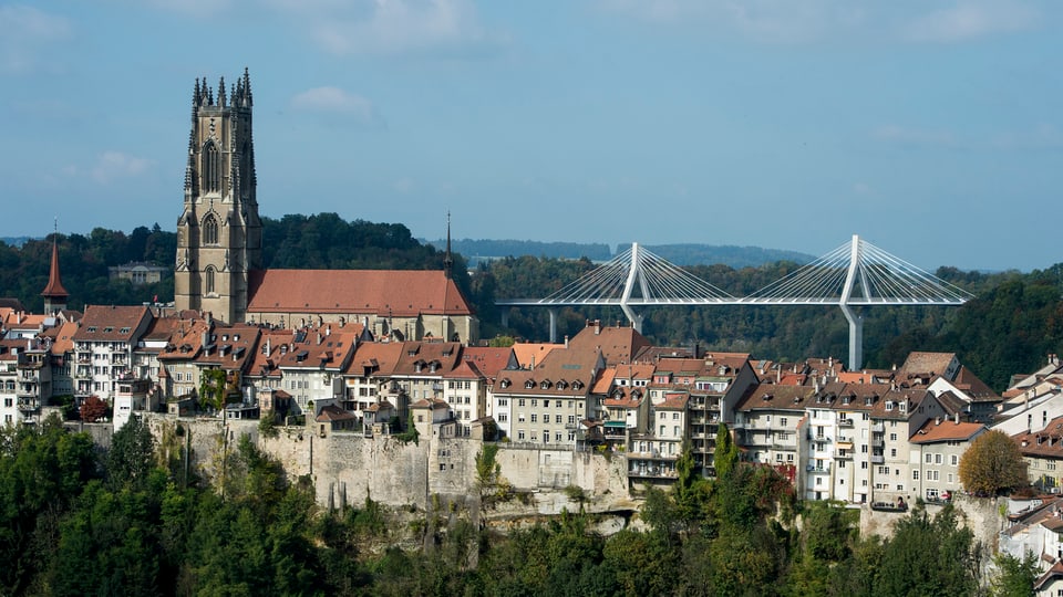 Der Stadtkern von Freiburg mit Kirche, dahinter die neue weisse Schrägseilbrücke
