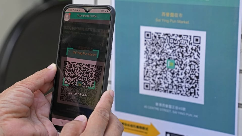 Eine Frau scannt einen QR-Code mit ihrem Handy.