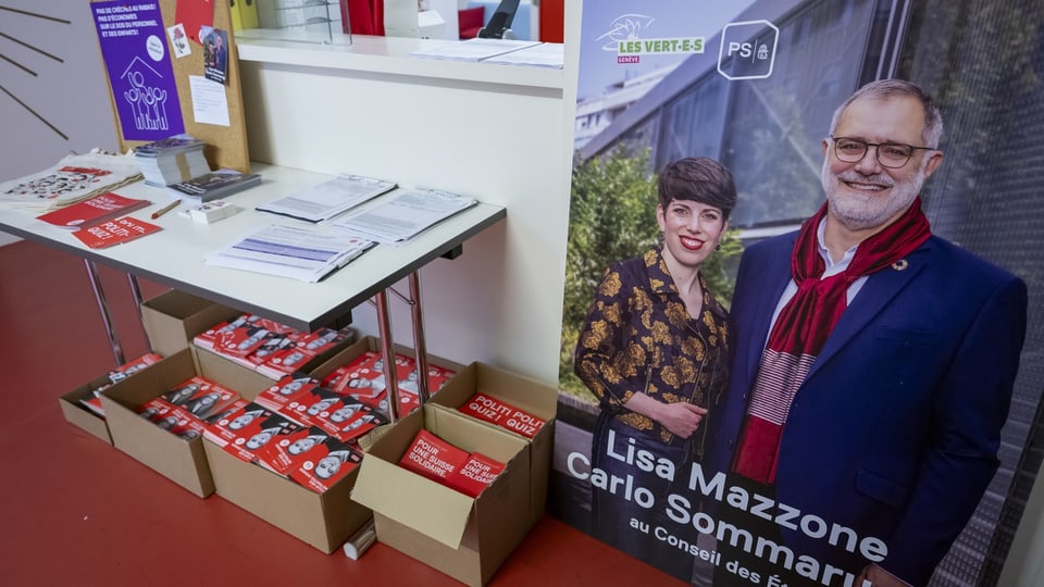 Ein Wahlplakat und Schachteln mit Flyern der SP Genf.