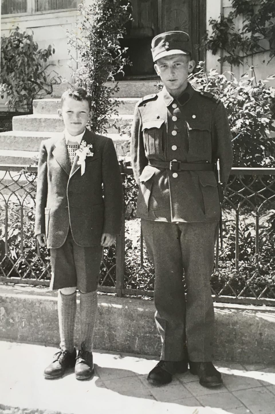 Ein junger Bursche und ein Mann in Militärkleidern.
