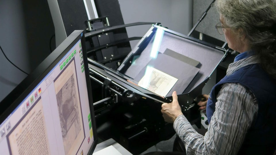 Eine Frau scannt ein altes Dokument ein.