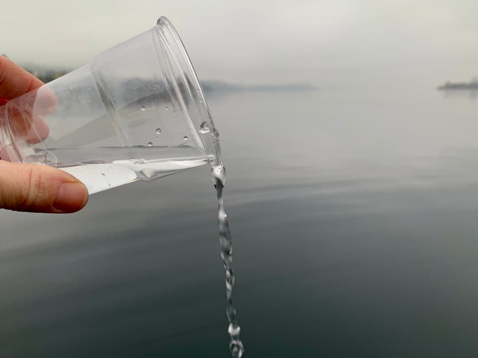 Glas Wasser im See auskippen