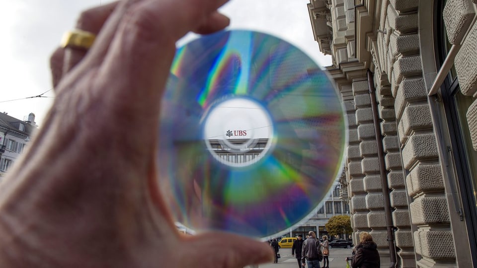 Symbolbild einer CD mit Steuerdaten vor einer UBS-Filiale