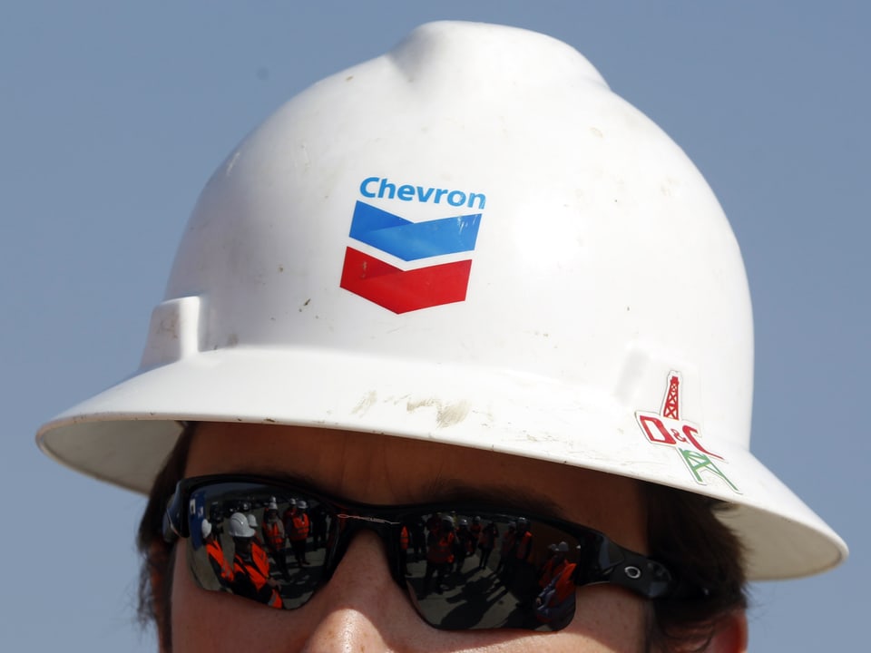 Ein Mann trägt einen Schutzhelm mit dem Chevron-Logo.