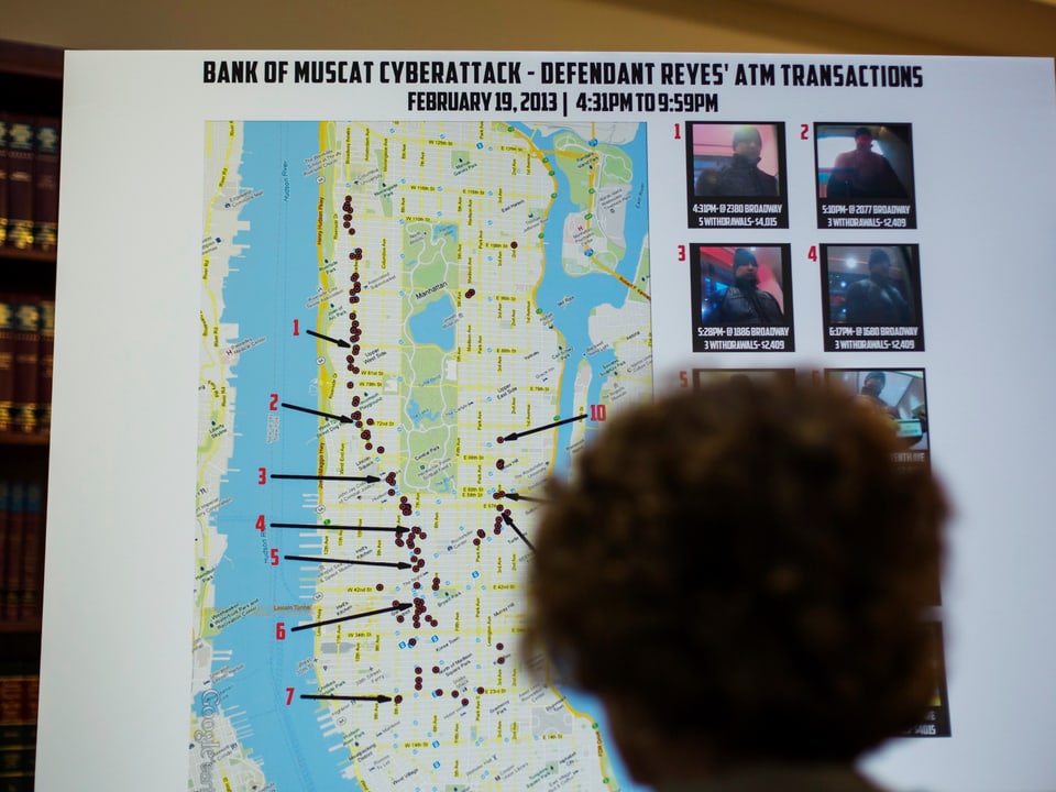 Eine Person steht vor einer Karte von New York, auf der zahlreiche Punkte markiert sind.