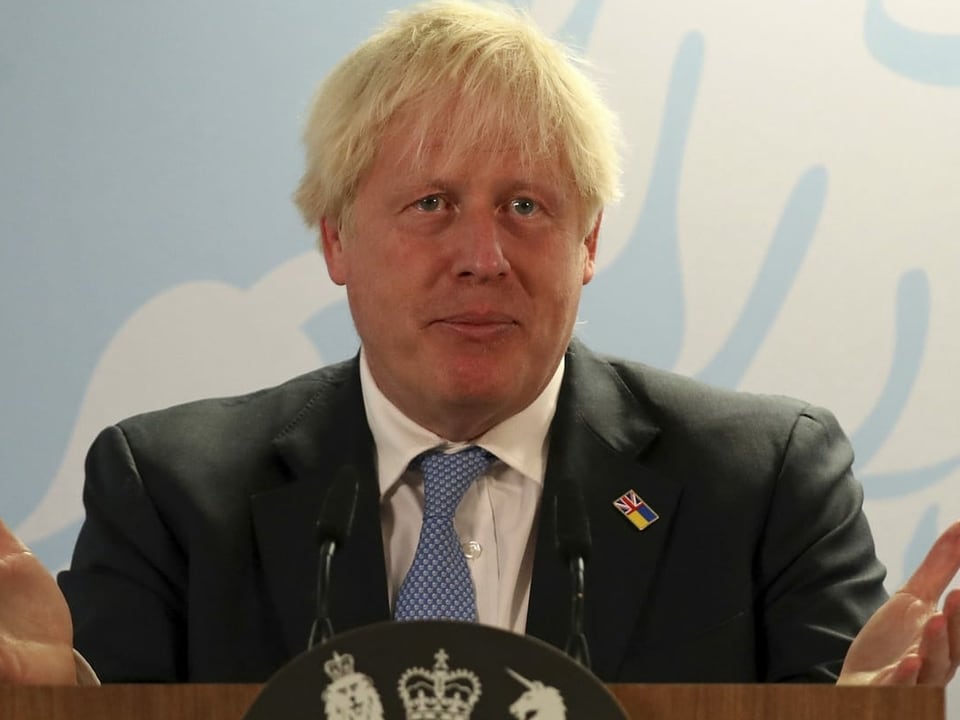 Boris Johnson am Rednerpult mit den Händen offen