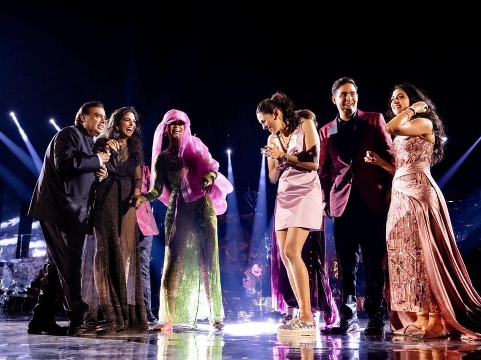 US-Popstar Rihanna (mit rosa Kappe) auf der Bühne mit dem künftigen Ehepaar.