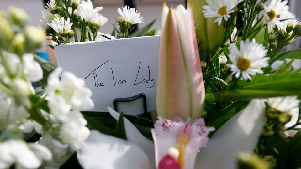 Inmitten von Blumen steckt ein Briefumschlag mit der Aufschrift «The Iron Lady»