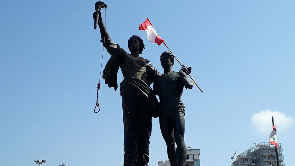Statue mit 2 Figuren: eine hält Galgen, die andere Libanons Flagge