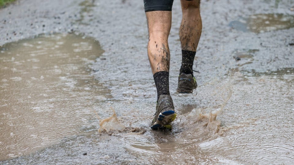  Ein Läufer passiert eine Wasserlache bei Filisur im Albulata. Der Grund:  Dauerregen am 29. Swiss Alpine Marathon über 78.5 Kilometer