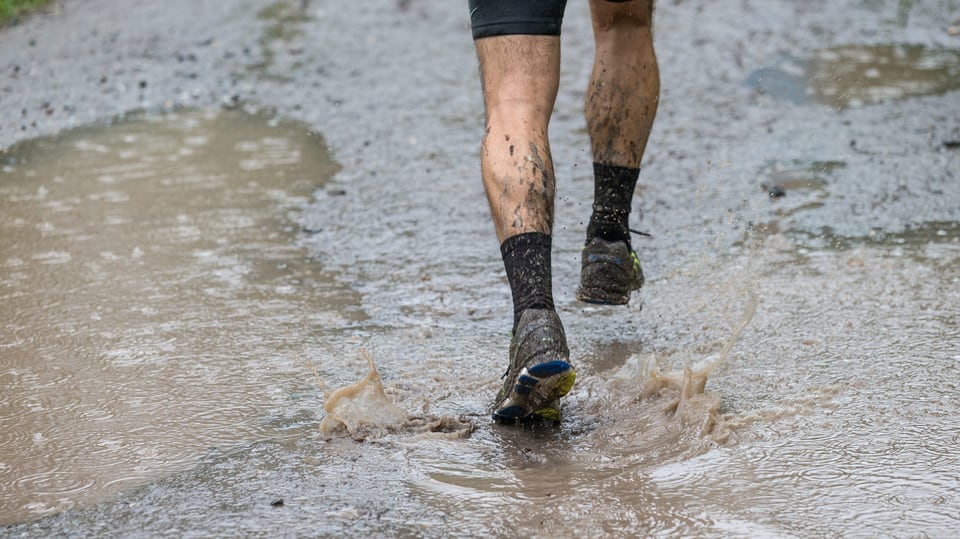 26. Juli Ein Läufer passiert eine Wasserlache bei Filisur im Albulata. Der Grund: Dauerregen am 29. Swiss Alpine Marathon über 78.5 Kilometer