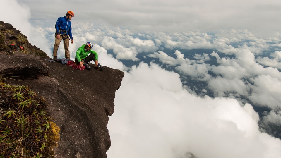 Zwei Bergsteiger auf der Spitze, unter ihnen das Wolkenmeer.