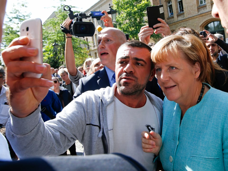 Ein Flüchtling macht ein Selfie mit Bundeskanzlerin Angela Merkel 