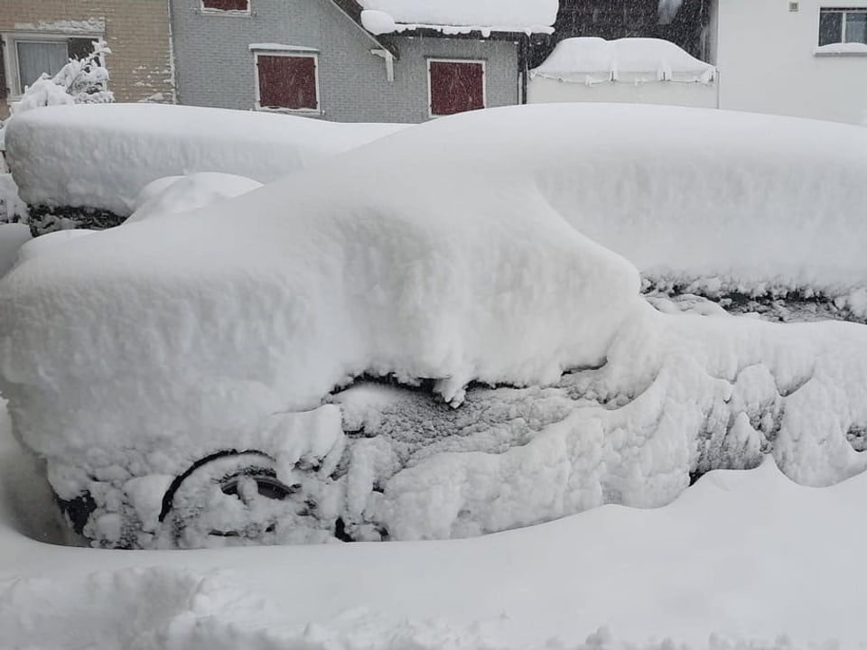 Ein Auto unter einer dicken Neuschneedecke