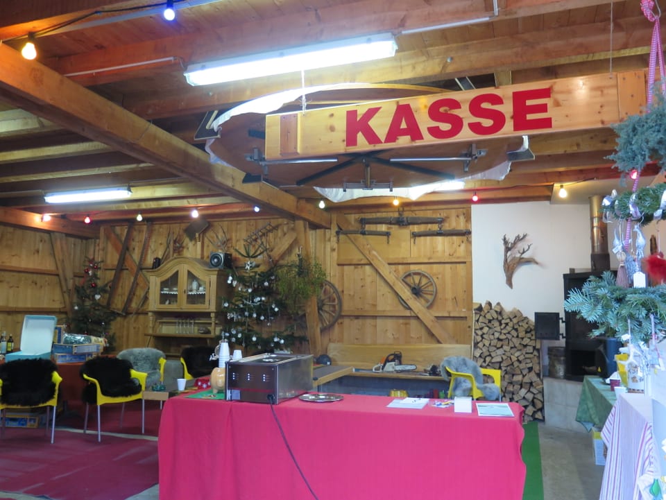 Raum in Holzhütte mit Schild Kasse.