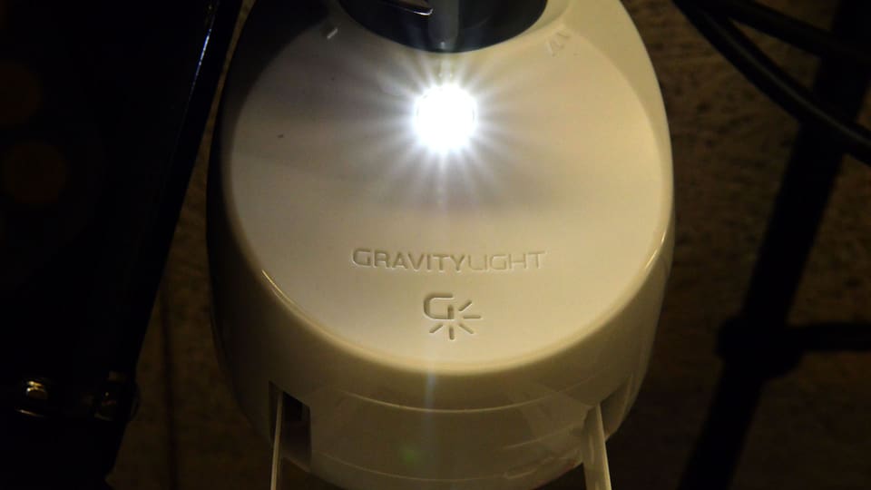 Das Gravity Light, ein Generator zum Aufhängen. An einer Kunstoffkette hängt ein schwerer Sack voller Steine, der den Generator antreibt und so Strom erzeugt.