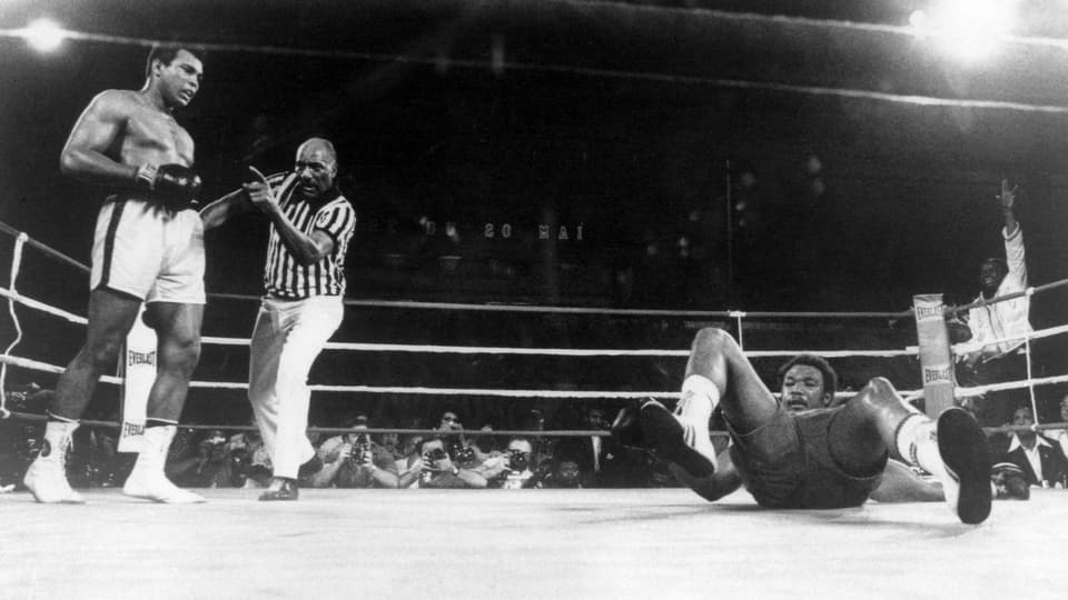 George Foreman am Boden. Der Schiedsrichter bremst Muhammad Ali